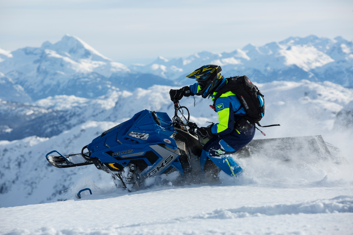 Man In Blue And Green Long-sleeved Suit Riding On Snowmobile